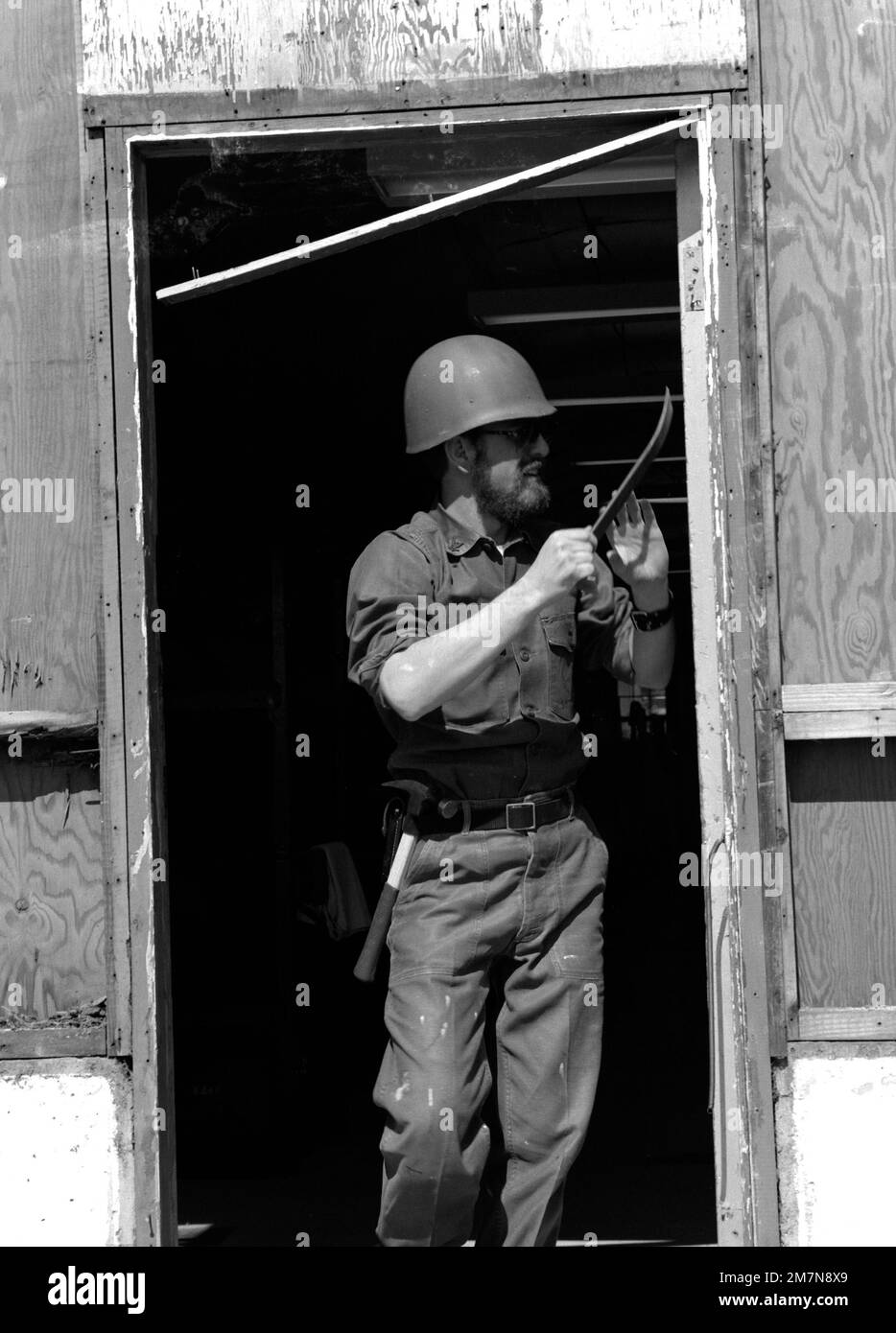 Costruttore 3rd Classe Kenneth L. Van Horn della Società D, 26th Riserva Navale costruzione mobile battaglione, dà la porta su una capanna di quesonce un lifting a Camp Upshur. Sta strappando fuori legno marcio prima di sostituire l'inceppamento della porta durante il suo addestramento di riserva al comando di sviluppo ed educazione del corpo Marino. Base: Marine Corps base, Quantico Stato: Virginia (VA) Paese: Stati Uniti d'America (USA) Foto Stock