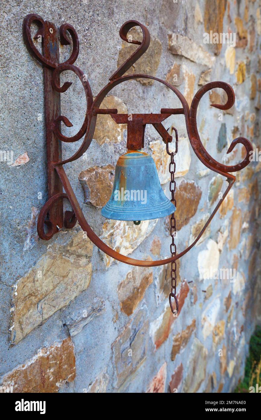 Il campanello blu della porta è appeso in una cornice di ferro arrugginito a Bagnone, Toscana occidentale Foto Stock