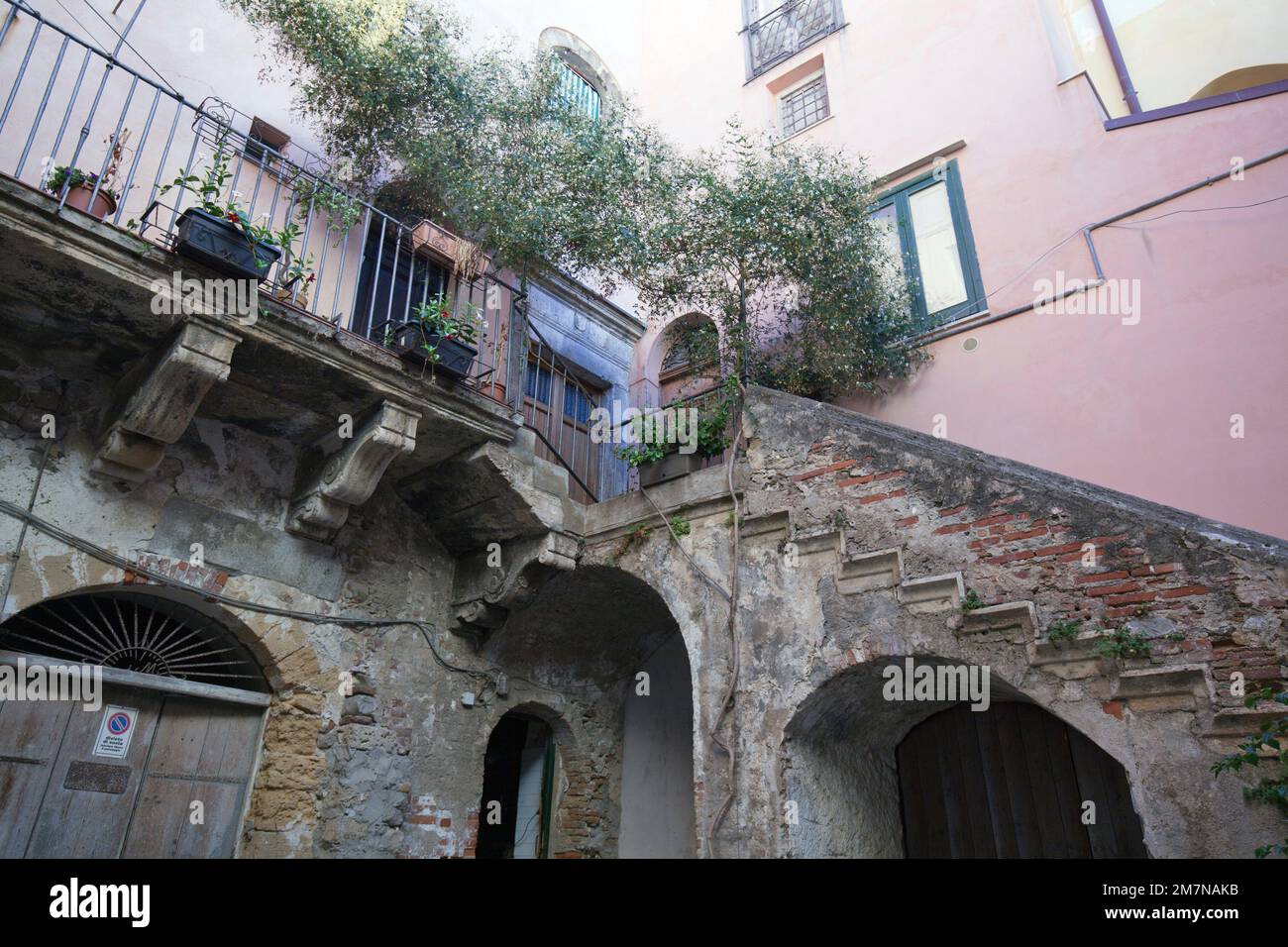Scale in pietra che conducono al balcone nel cortile a Cefalù, Sicilia Foto Stock