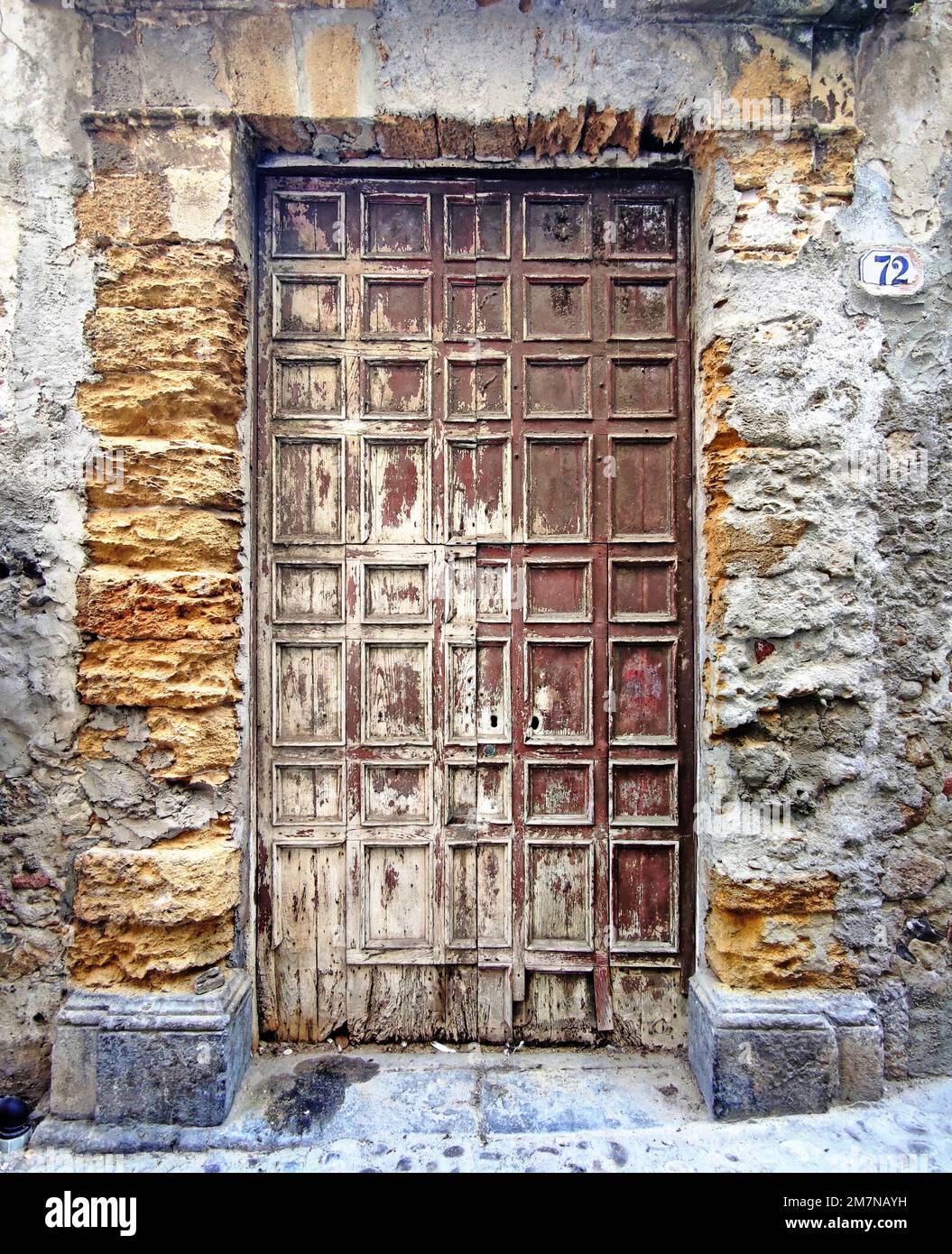 Vecchia porta in legno con pannelli a cassettoni in pietra da cava, Cefalù, Sicilia Foto Stock