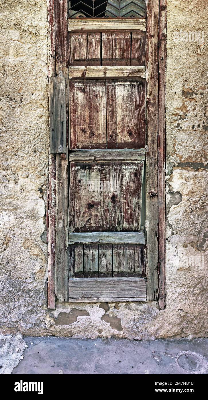 Stretta porta in legno in una casa muraria nel villaggio di Menfi, Sicilia Foto Stock