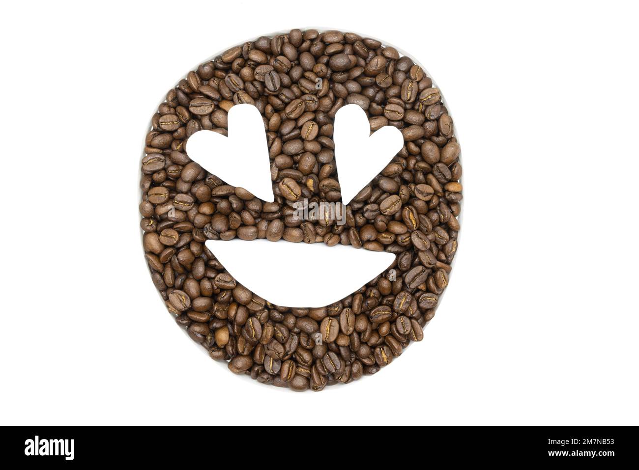 Chicchi di caffè disposti su uno sfondo bianco per apparire come un emoji Foto Stock