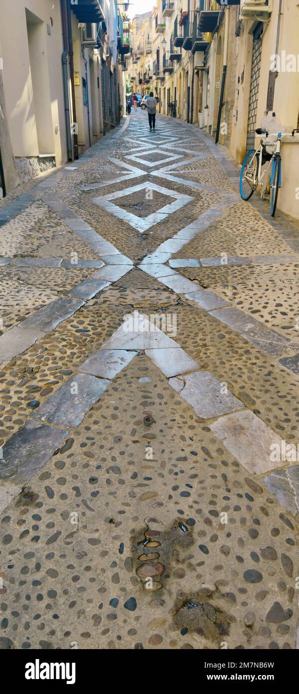 Vicolo lastricato con lastre di pietra levigata a Cefalù, Sicilia Foto Stock
