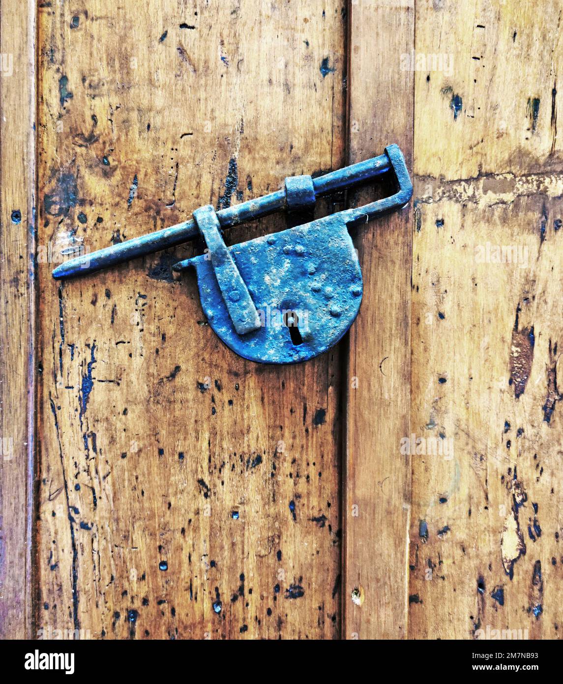 Lucchetto in ferro battuto su porta in legno nel villaggio di Cefalù, in Sicilia Foto Stock