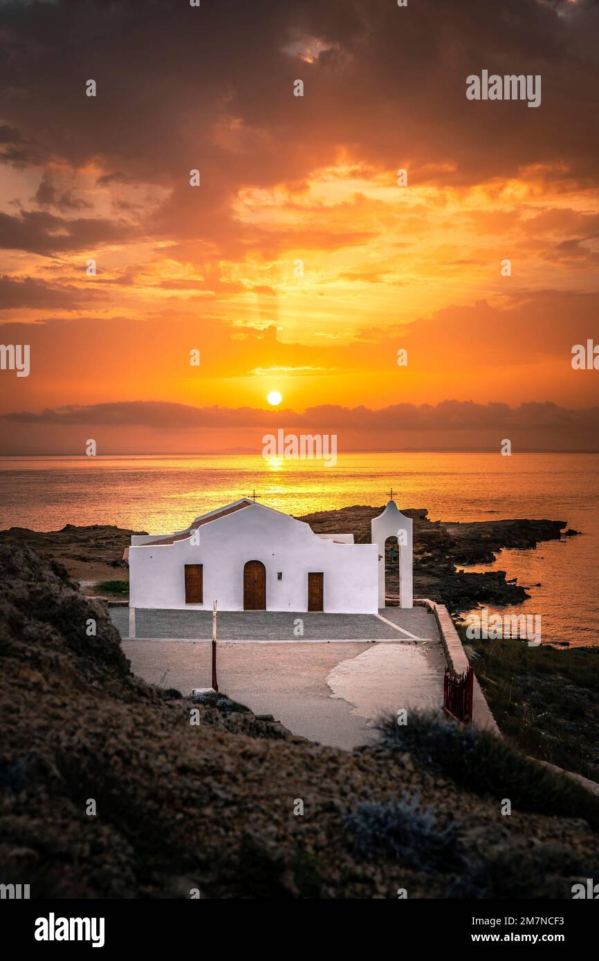 Vista di un'alba sul mare, la Cappella di Agios Nikolaos su una roccia in controluce, Zakyntos, Isole IONIE, Grecia Foto Stock