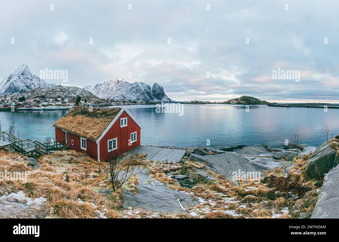 Tradizionale rorbu cabina / casa a Lofoten, Norvegia, tipico paesaggio fiordo con montagne, villaggio di pescatori e vista sul mare Foto Stock