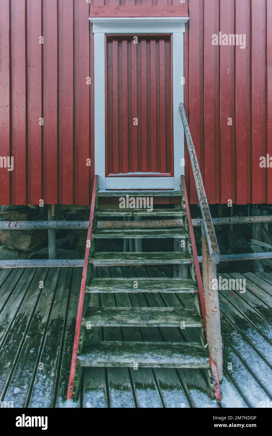 Porta rossa con scale, Nusfjord, capanna di pesca rossa, villaggio di pescatori, Lofoten, Nordland, Norvegia Foto Stock