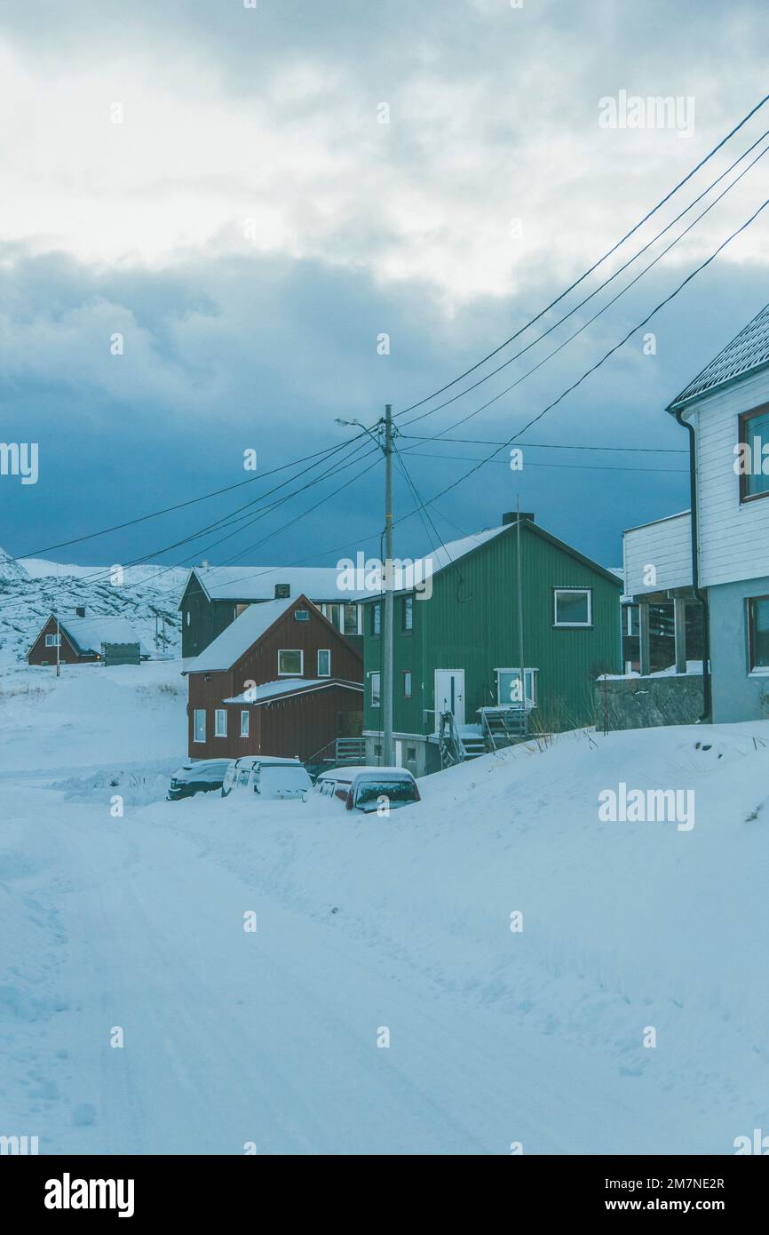 Villaggio di pescatori solitario e nevoso sul fiordo in Norvegia, tipico paesaggio fiordo con neve, isolamento dal mondo esterno Foto Stock