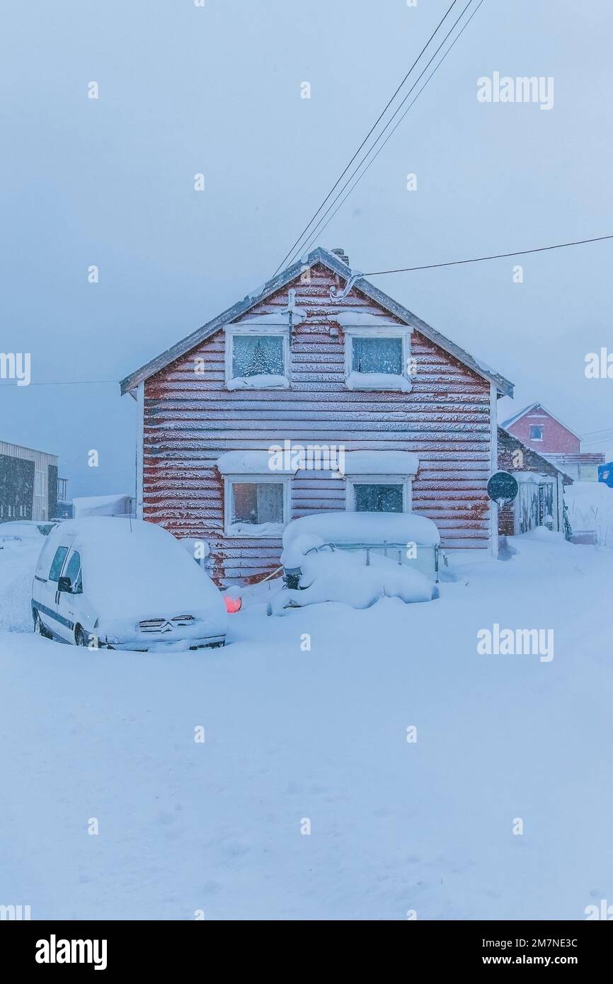 Villaggio di pescatori solitario e nevoso sul fiordo in Norvegia, tipico paesaggio fiordo con neve, isolamento dal mondo esterno Foto Stock