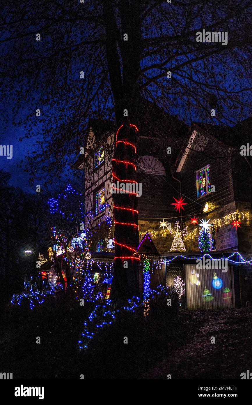 Vecchia casa a graticcio con colorate luci di Natale di fronte alla casa Foto Stock