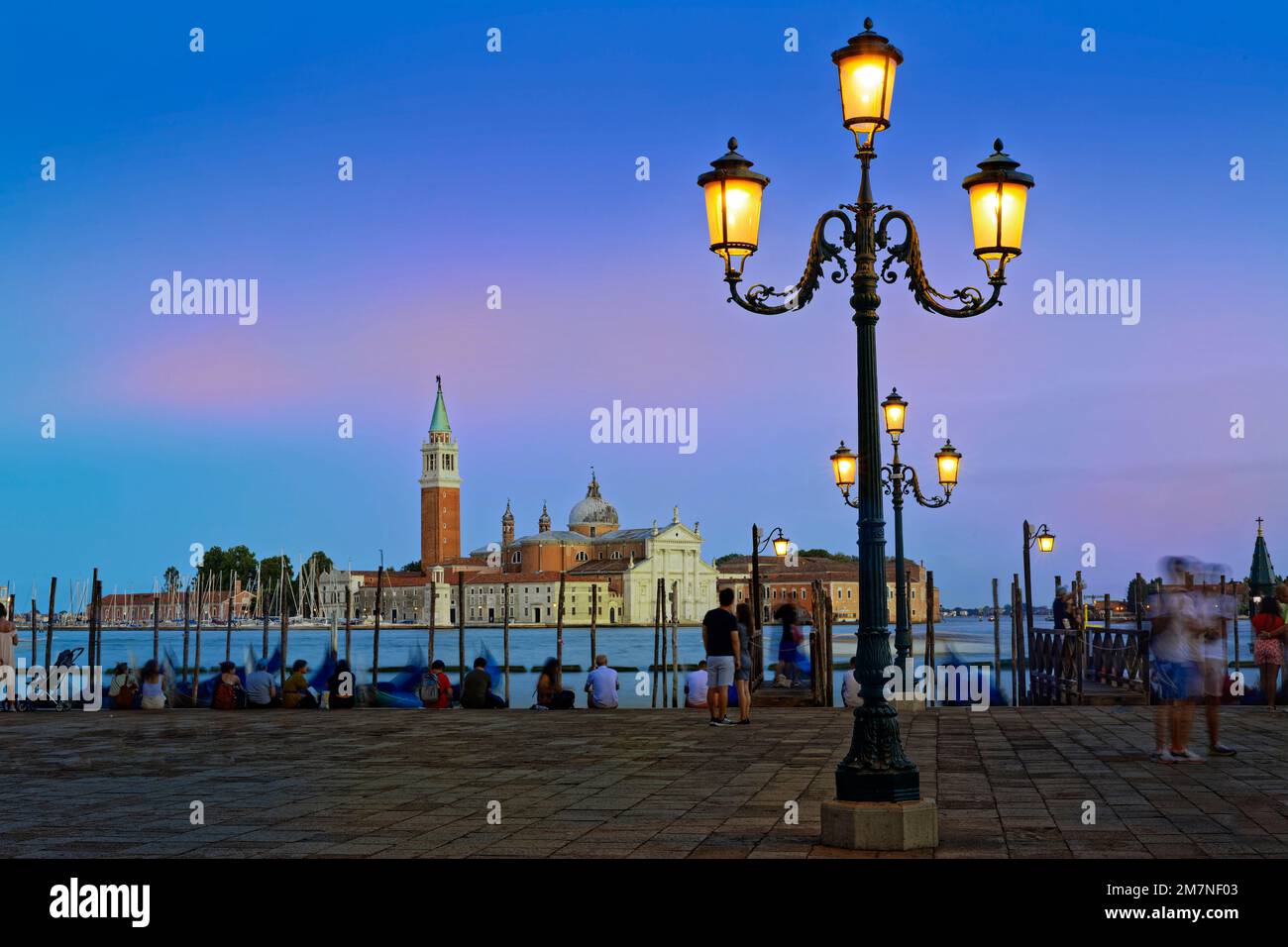 All'ora Blu in Piazza San Marco con le sue magnifiche luci. Sullo sfondo, San Giorgio maggiore, un'abbazia benedettina del 16th° secolo su un'isola omonima. Foto Stock