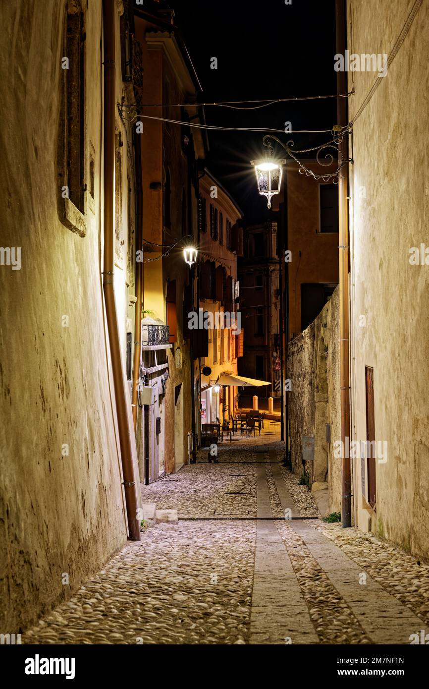 Vicolo illuminato nella città nord italiana di Vittorio Veneto Foto Stock