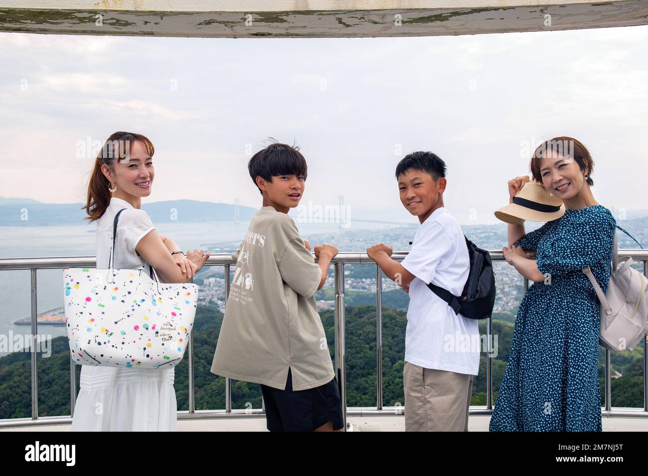 Quattro giapponesi in un'escursione, due donne mature e due ragazzi di 13 anni, in fila, su una piattaforma di osservazione. Foto Stock