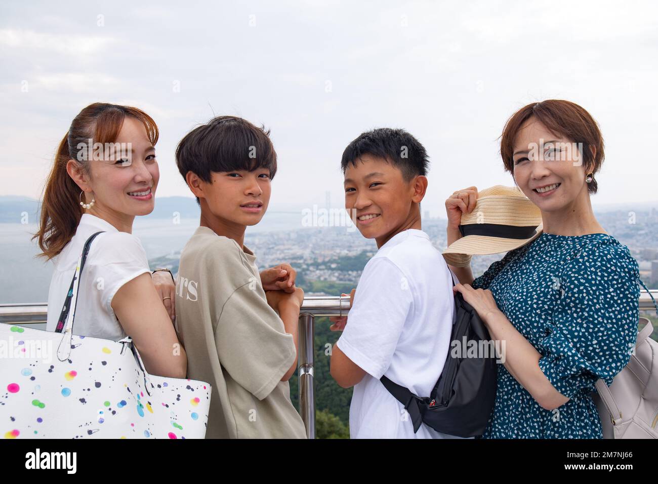 Quattro giapponesi in un'escursione, due donne mature e due ragazzi di 13 anni, in fila, su una piattaforma di osservazione. Foto Stock