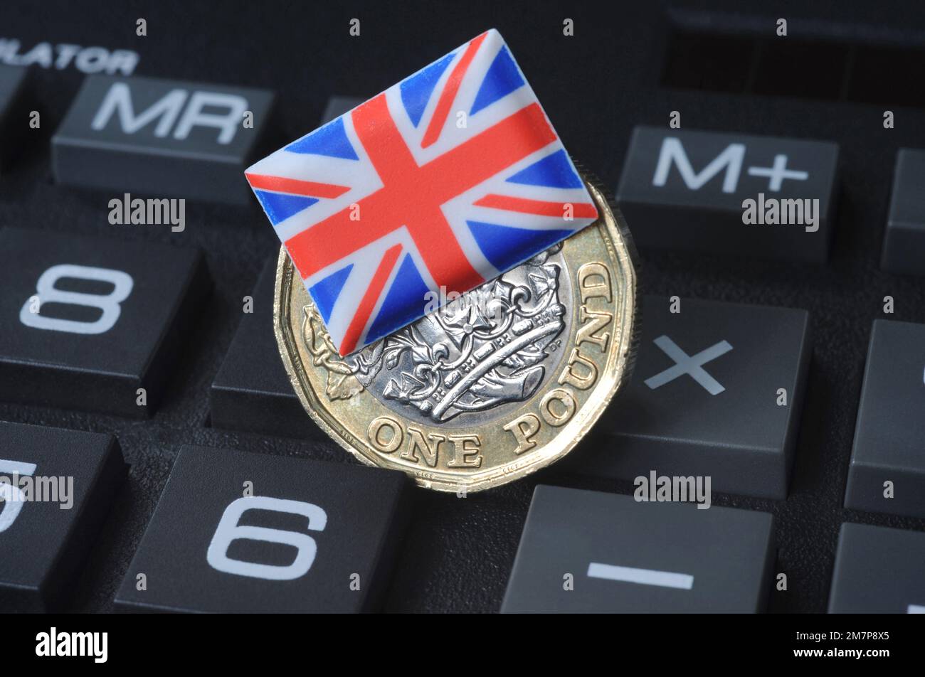 MONETA BRITANNICA DI UNA LIBBRA CON LA BANDIERA DELL'UNIONE SUL CALCOLATORE RE COSTO DI CRISI VIVENTE L'INFLAZIONE DI ECONOMIA ECC REGNO UNITO Foto Stock