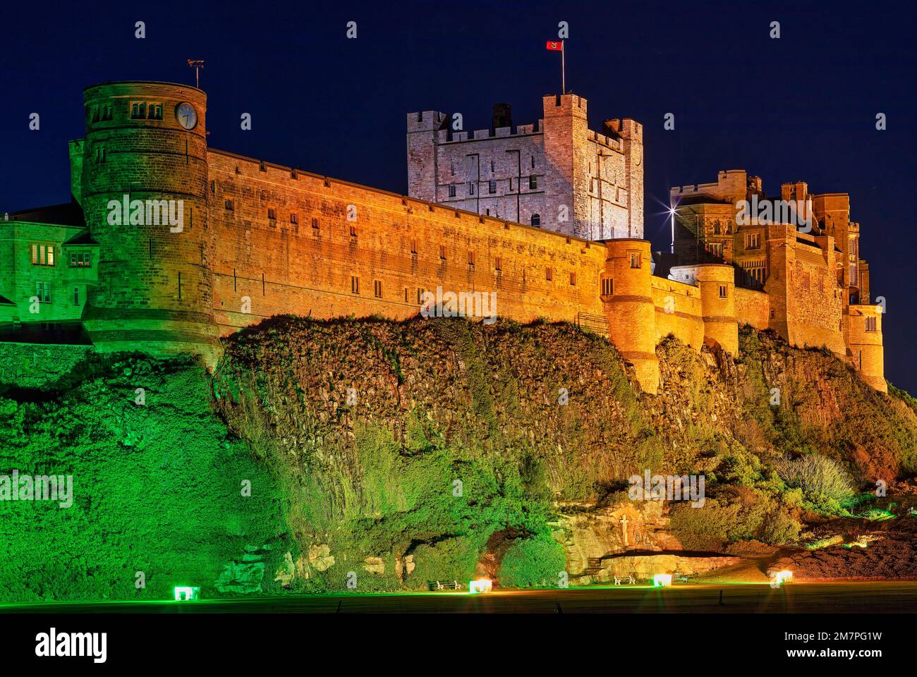 Castello di Bamburgh illuminato di notte, Northumberland, Inghilterra, Regno Unito Foto Stock