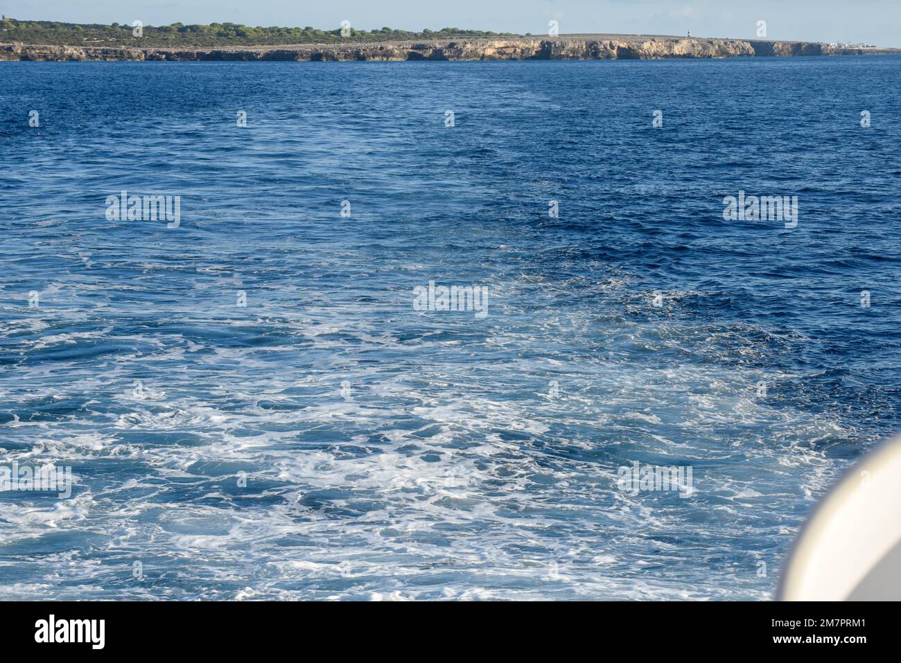 Vista dal retro di una barca a vela lontano da un'isola Foto Stock Vista dal retro di una barca a vela lontano da un'isola Foto Stock