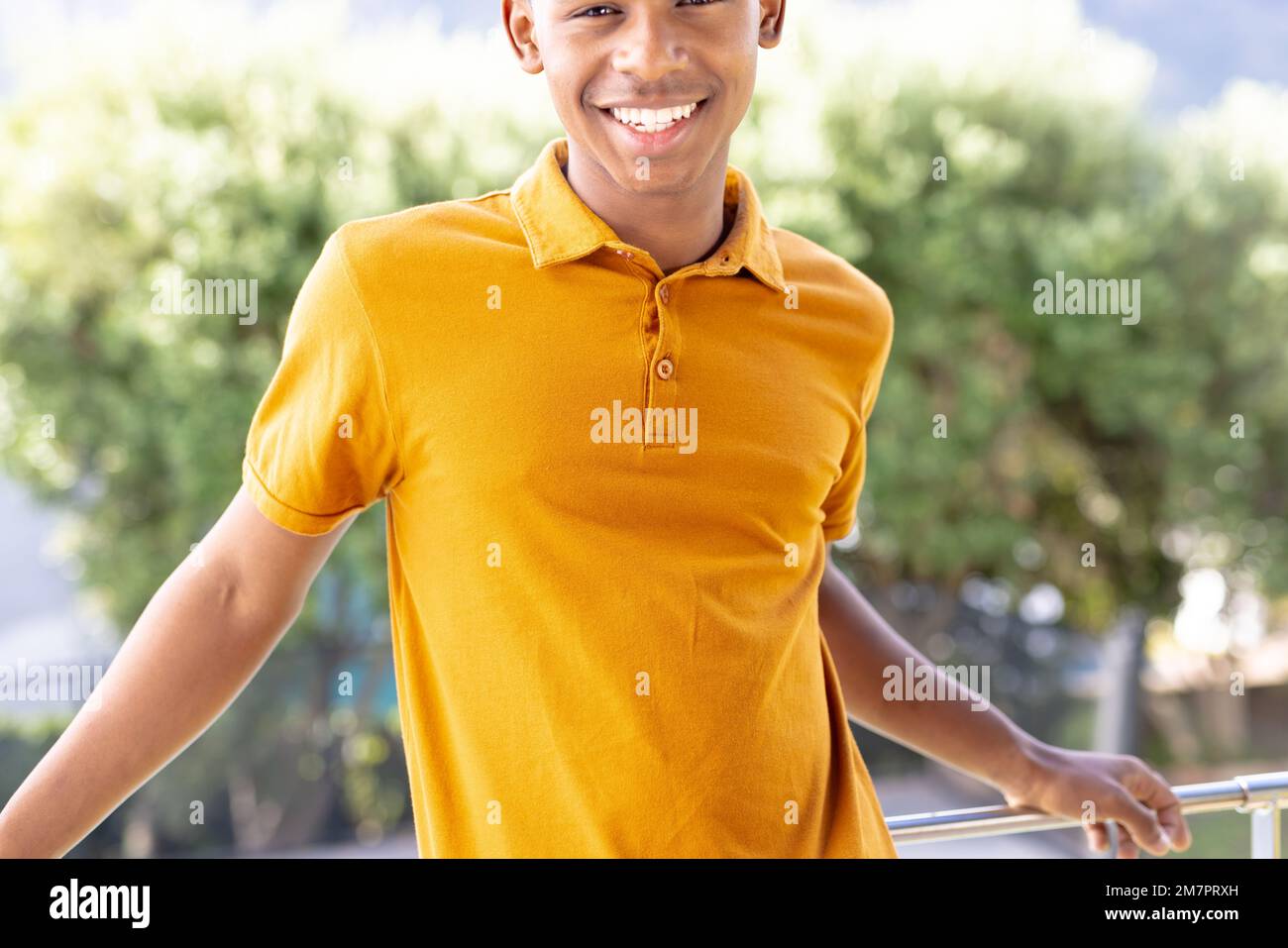 Immagine dell'uomo biraciale in polo arancione a manica corta con copyspace Foto Stock