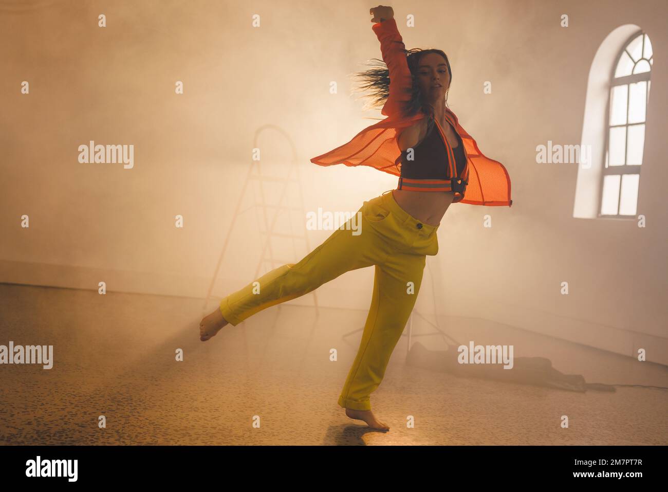 Immagine di danza moderna femminile biraciale in interni affumicati Foto Stock