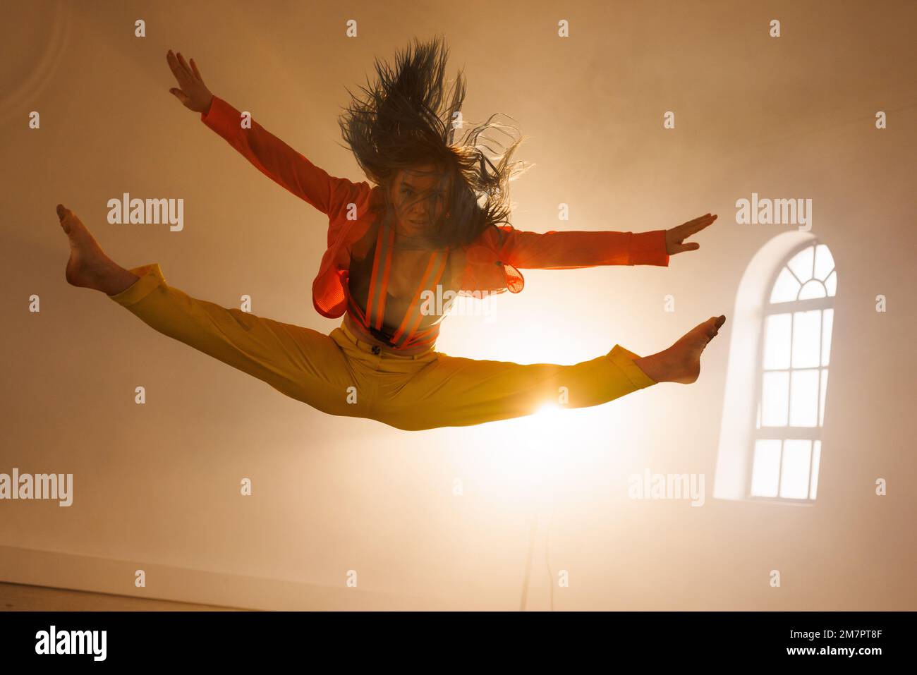 Immagine di danza moderna femminile biraciale in interni affumicati Foto Stock