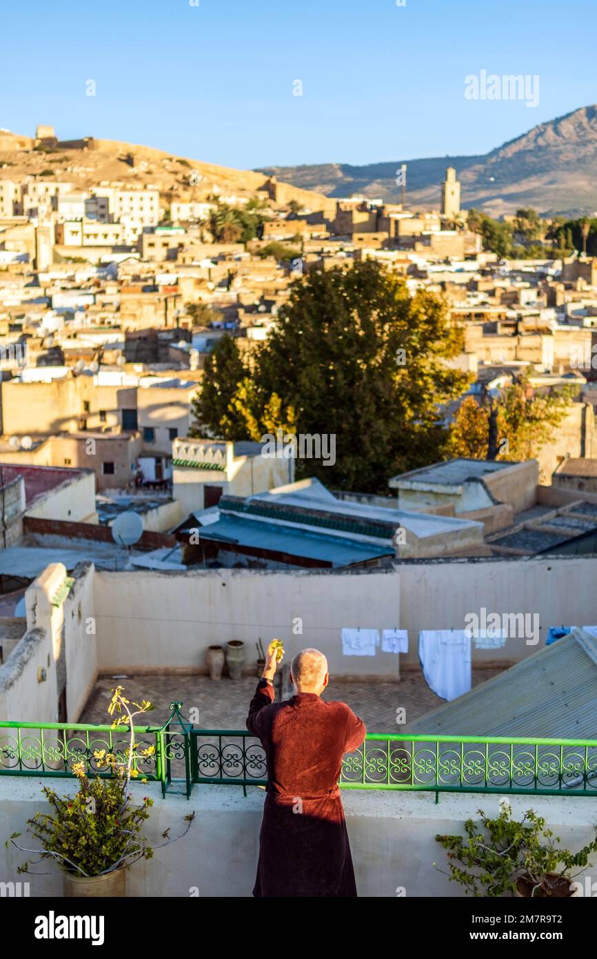 Uomo sul tetto godendo di vista della vecchia medina araba di Fez, Marocco, Nord Africa Foto Stock