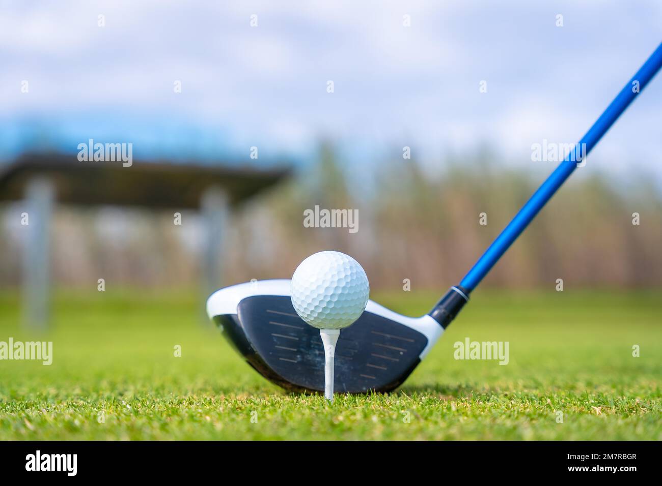 Uomo che gioca a golf al golf club vicino a un lago, preparandosi a colpire Foto Stock