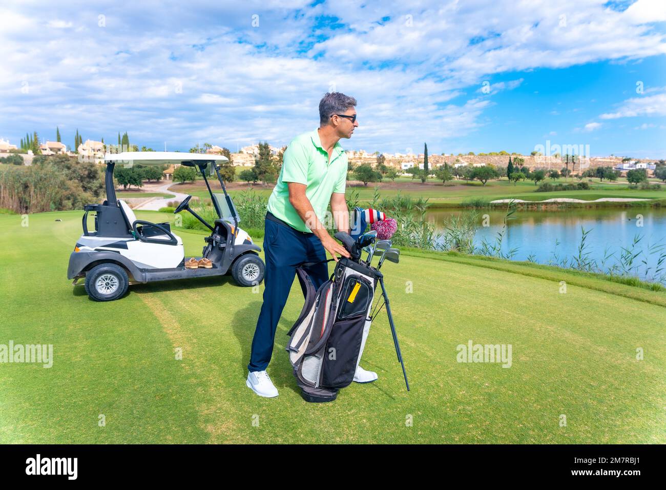 Uomo che gioca a golf preparando il club a colpire, golf club, conducente, ferro da stiro, pitching Foto Stock
