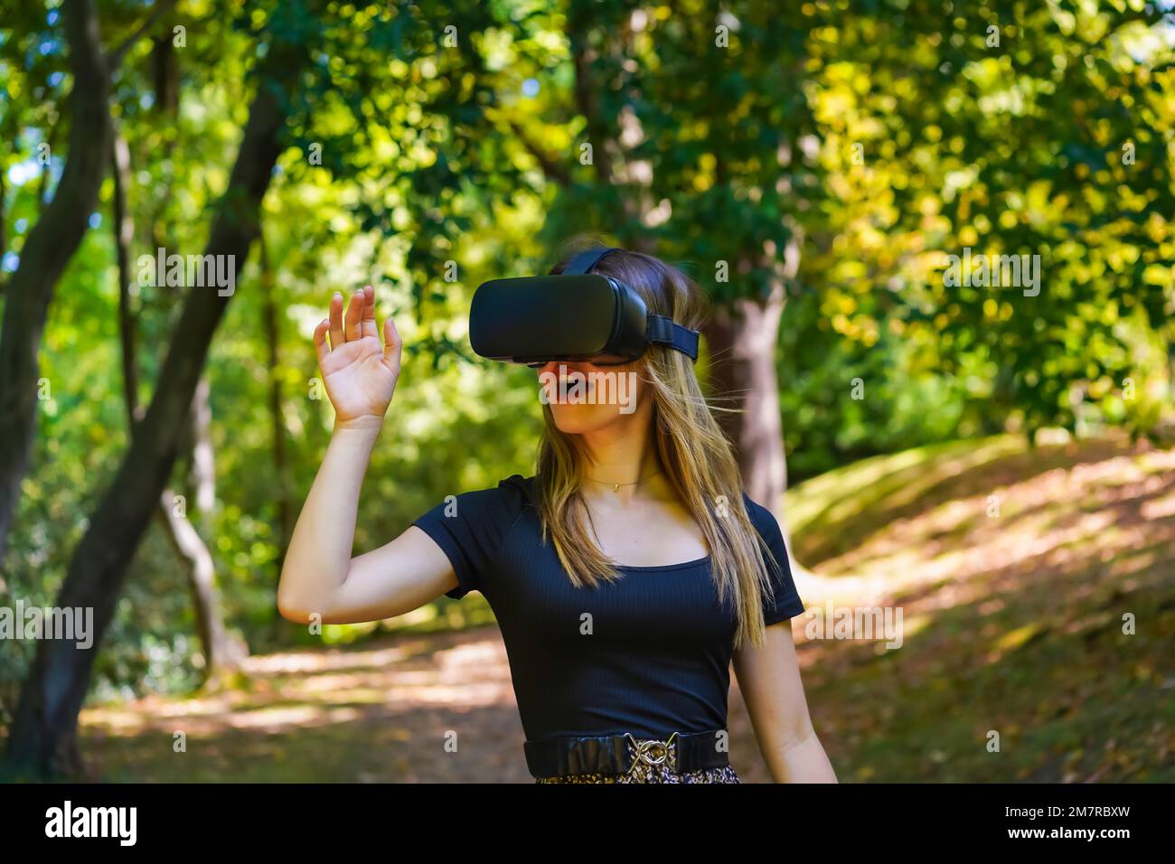 Donna con occhiali per realtà virtuale che si gode la natura vedendo le cose negli occhiali Foto Stock