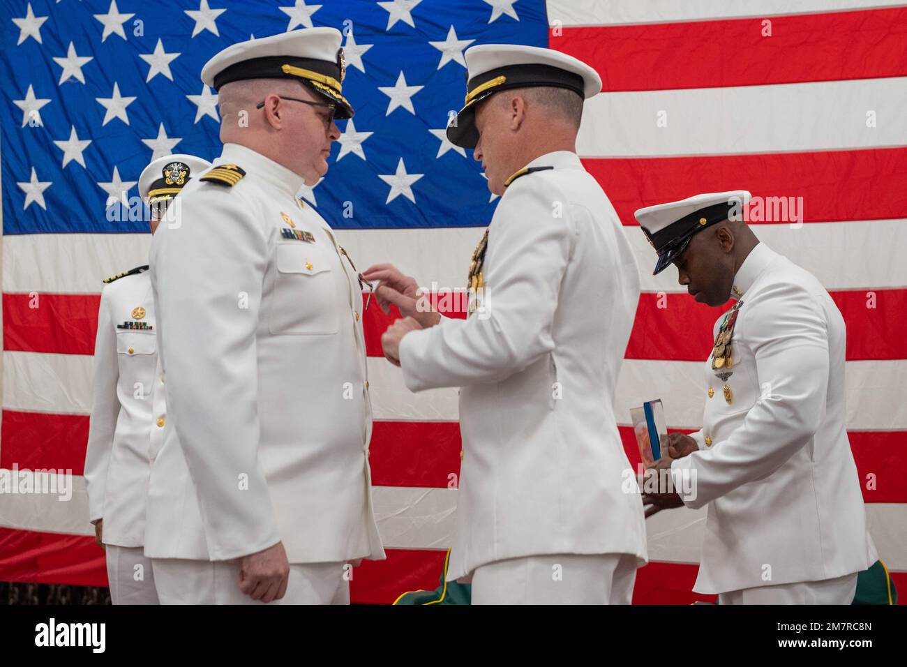 SASEBO, Giappone (12 maggio 2022) il capitano James T. Robinson, comandante della nave portuale di trasporto anfibio USS Green Bay (LPD 20), riceve la Meritorious Service Medal durante una cerimonia di cambio di comando nella zona di stivaggio dei veicoli della nave. Green Bay, parte dello Squadrone anfibio 11, opera nell'area di responsabilità della flotta degli Stati Uniti 7th per migliorare l'interoperabilità con alleati e partner e funge da pronta forza di risposta per difendere la pace e la stabilità nella regione dell'Indo-Pacifico. Foto Stock