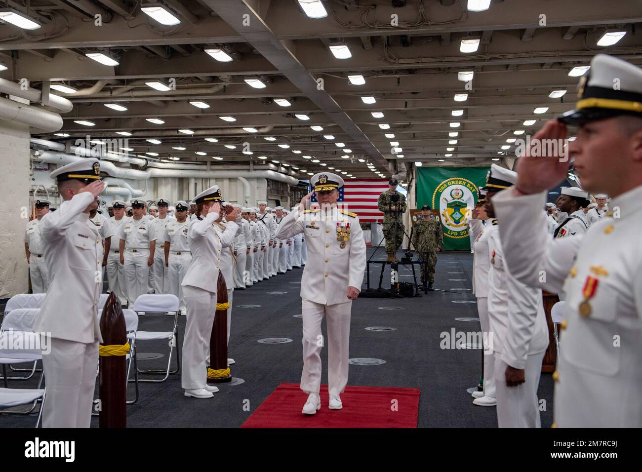 SASEBO, Giappone (12 maggio 2022) ADM posteriore Chris Engdahl, comandante, Expeditionary Strike Group 7, presidente del cambio di comando della nave da trasporto anfibia USS Green Bay (LPD 20), arriva alla cerimonia nella zona di stivaggio dei veicoli della nave. Green Bay, parte dello Squadrone anfibio 11, opera nell'area di responsabilità della flotta degli Stati Uniti 7th per migliorare l'interoperabilità con alleati e partner e funge da pronta forza di risposta per difendere la pace e la stabilità nella regione dell'Indo-Pacifico. Foto Stock