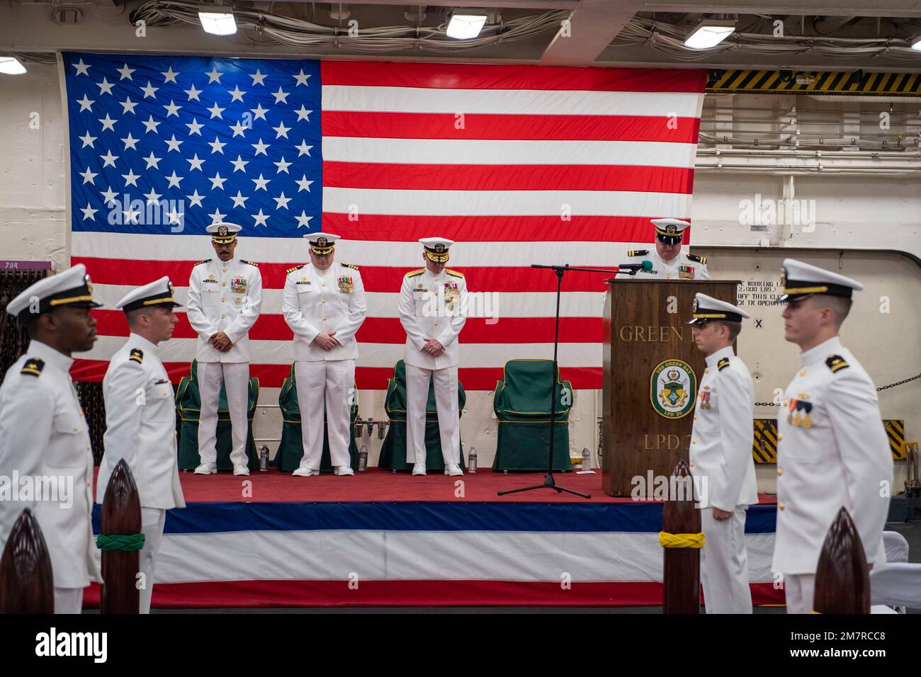 SASEBO, Giappone (12 maggio 2022) il Lt. John Kenny, cappellano di comando a bordo della nave portuale di trasporto anfibio USS Green Bay (LPD 20), dà la benevolenza di concludere una cerimonia di cambio di comando nella zona di stivaggio dei veicoli della nave. Green Bay, parte dello Squadrone anfibio 11, opera nell'area di responsabilità della flotta degli Stati Uniti 7th per migliorare l'interoperabilità con alleati e partner e funge da pronta forza di risposta per difendere la pace e la stabilità nella regione dell'Indo-Pacifico. Foto Stock