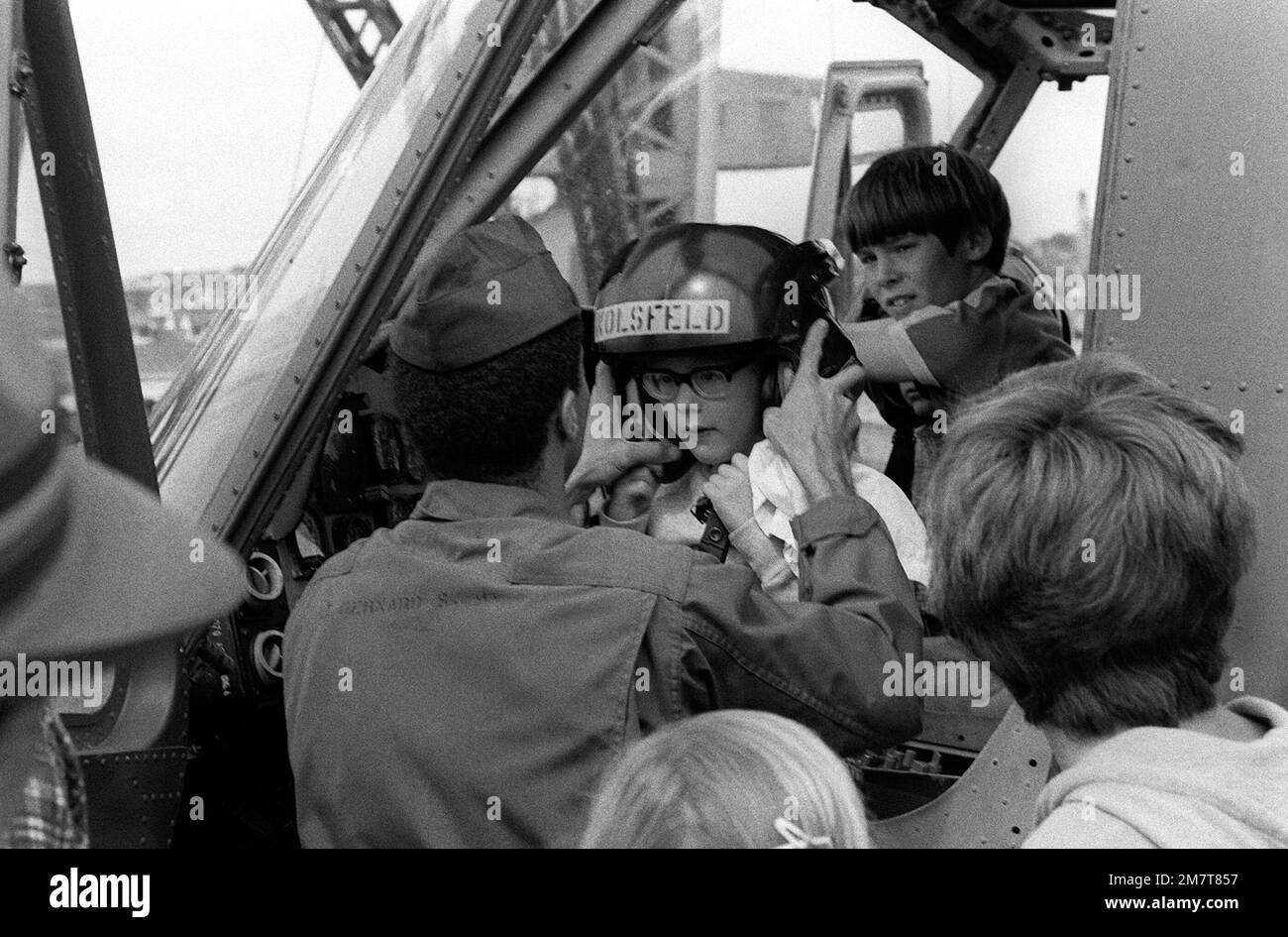 Mentre attraccata, la nave d'assalto anfibia USS OKINAWA (LPH-3) ha una casa aperta per il pubblico. Un membro del Marine Medium Helicopter Squadron 262 (HMM-262) aiuta un giovane australiano a indossare il casco di un pilota mentre siede in un elicottero Iroquois UH-1. La 31st Marine Amphibious Unit è in Australia per partecipare al Kangaroo 4 (1981). Base: Sydney Stato: Nuovo Galles del Sud Paese: Australia (AUS) Foto Stock