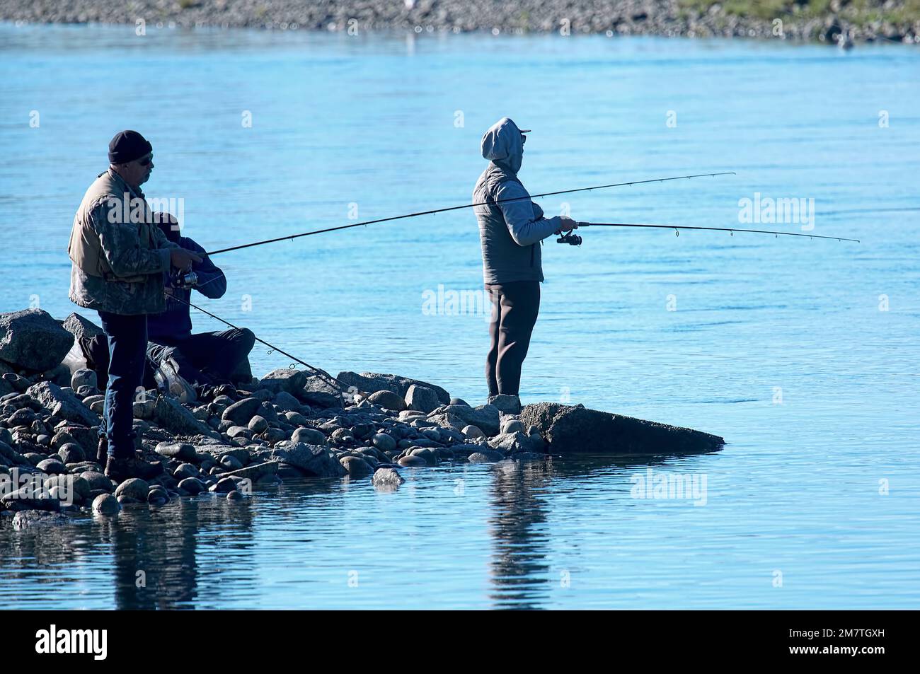Pescatori retroilluminati che peschano dalla riva. Metro Vancouver, British Columbia, Canada. Novembre 2020. Foto Stock