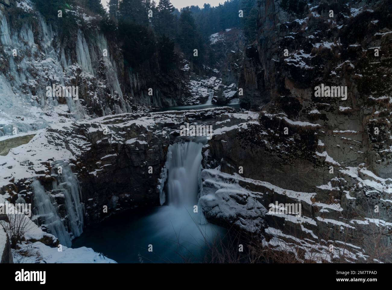 Una lunga esposizione di cascata parzialmente congelata di Aharbal durante una fredda giornata nuvolosa a Kulgam. Le acque del fiume Veshu, creano una delle cascate più maestose conosciute come le cascate di Aharbal o Niagara del Kashmir. Le cascate hanno un ambiente panoramico composto da fitte foreste di abeti, situato a sud di Srinagar. E' una delle migliori destinazioni turistiche nella Valle del Kashmir. Foto Stock