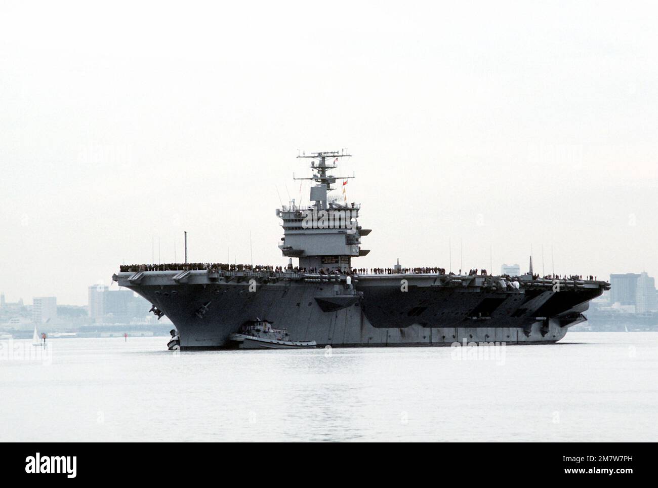 Vista di prua portuale della portaerei a energia nucleare USS ENTERPRISE (CVN-65) assistita in posizione di attracco dal grande rimorchiatore portuale USS POUGHKEEPSIE (YTB-813). L'IMPRESA sta ritornando da una breve crociera alla conclusione del recente rinnovamento che ha incluso la ricostruzione della sovrastruttura. Base: Naval Air Station, Alameda Stato: California (CA) Paese: Stati Uniti d'America (USA) Foto Stock