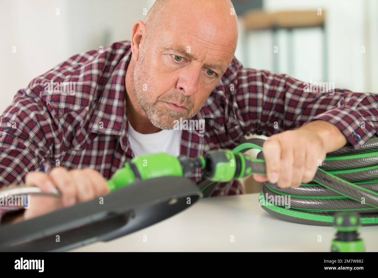 un uomo collega i tubi flessibili Foto Stock