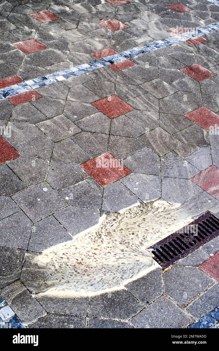 Polline giallo nell'acqua sul marciapiede della città. Foto Stock