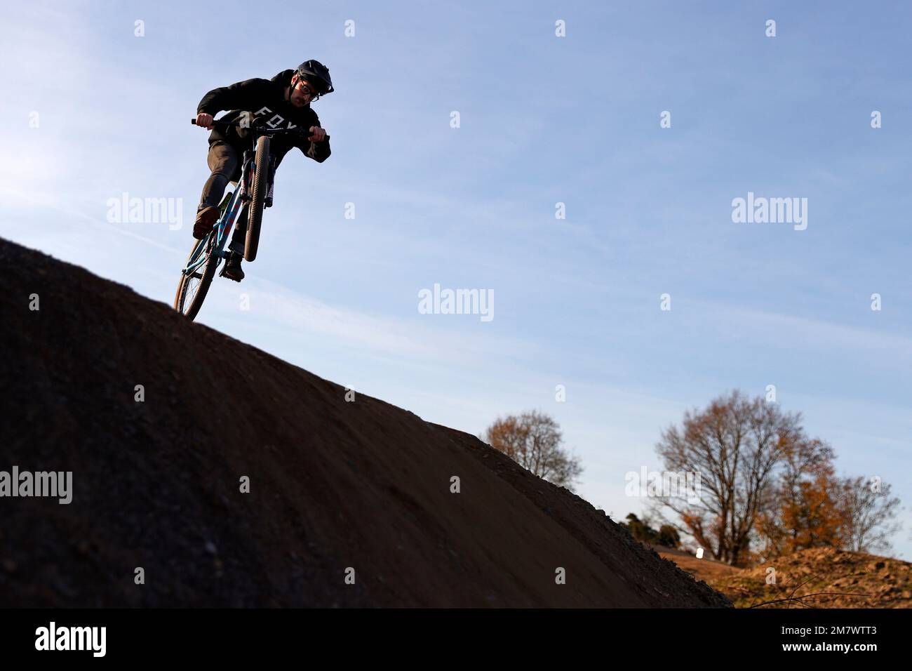 La gente salta le loro mountain bike ad un BMX e pompa pista a Fleet, Hampshire. Foto Stock
