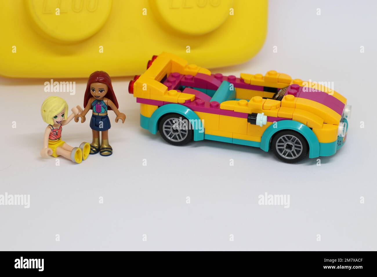 2 mini figure di lego accanto a una macchina sportiva di lego che tiene le mani Foto Stock