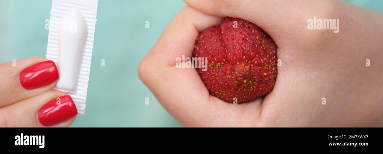 La mano della donna tiene le candele mediche per la costipazione e l'anatomia dell'ano Foto Stock