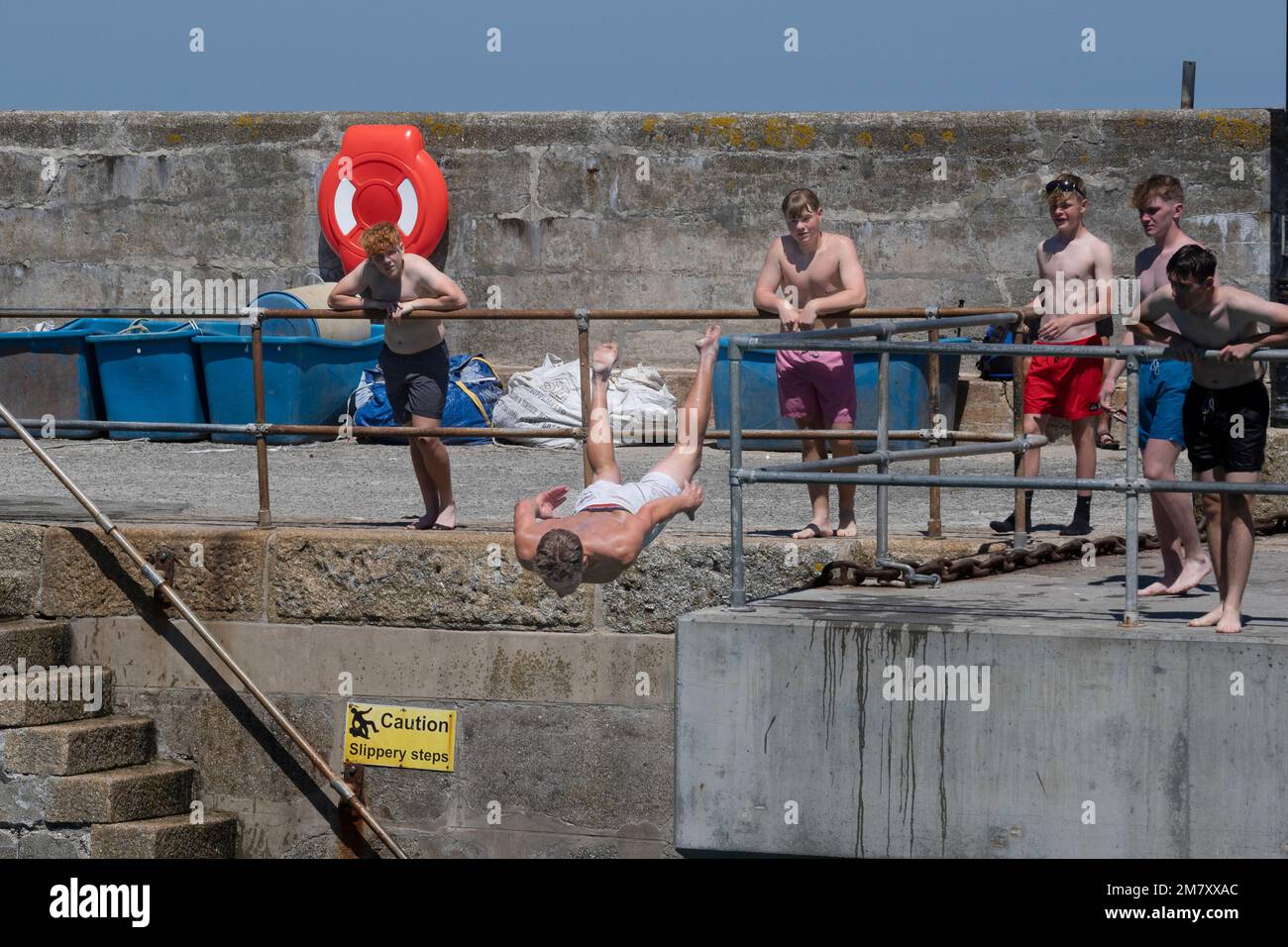 Un villeggiante che si tuffa nel mare a Newquay Harbour in Cornovaglia in Inghilterra nel Regno Unito. Foto Stock