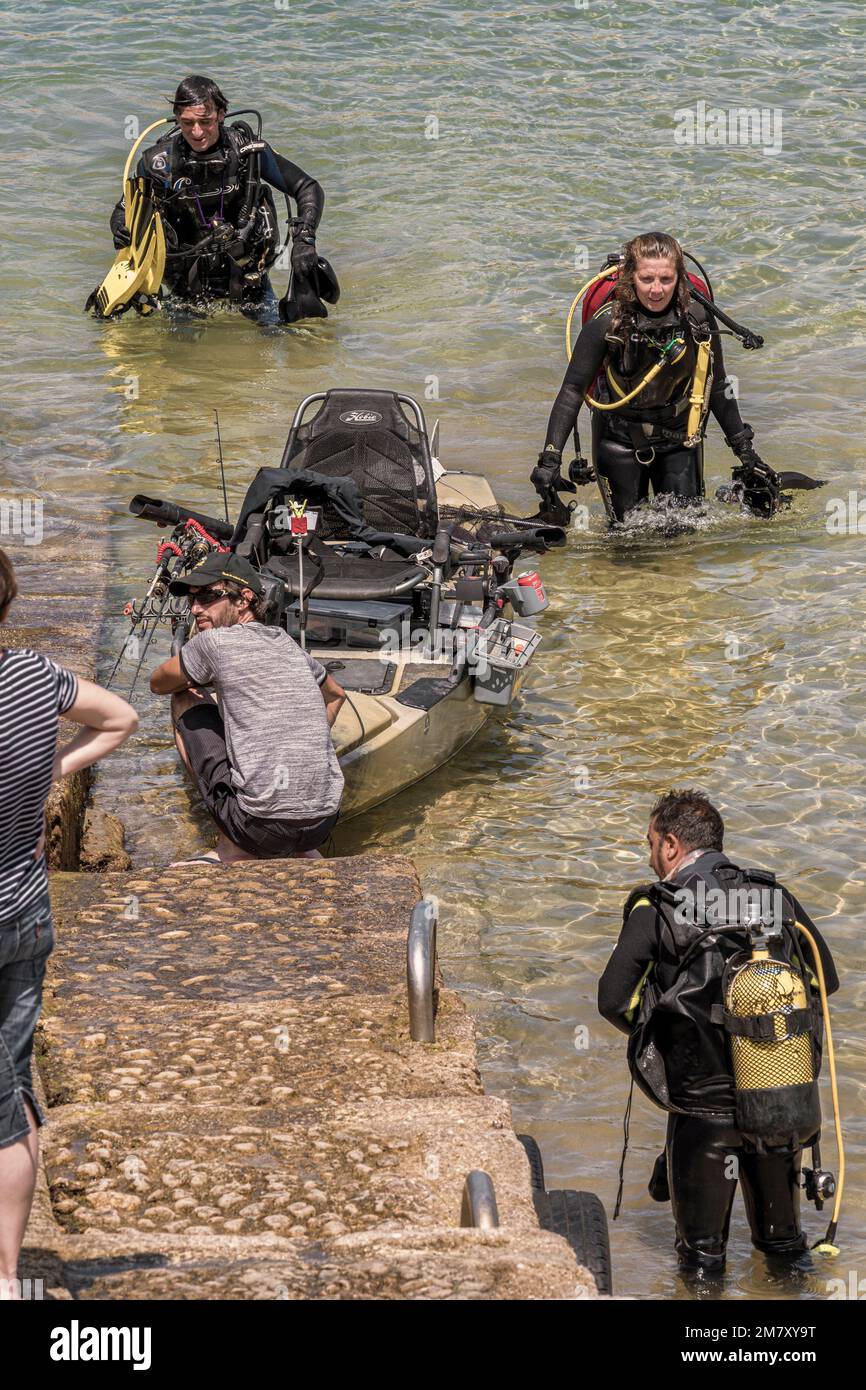 Persone che guardano una formazione fittizia di subacquei DYA, canoe e barche di salvataggio nella piccola città di Islares, Cantabria, Spagna Foto Stock