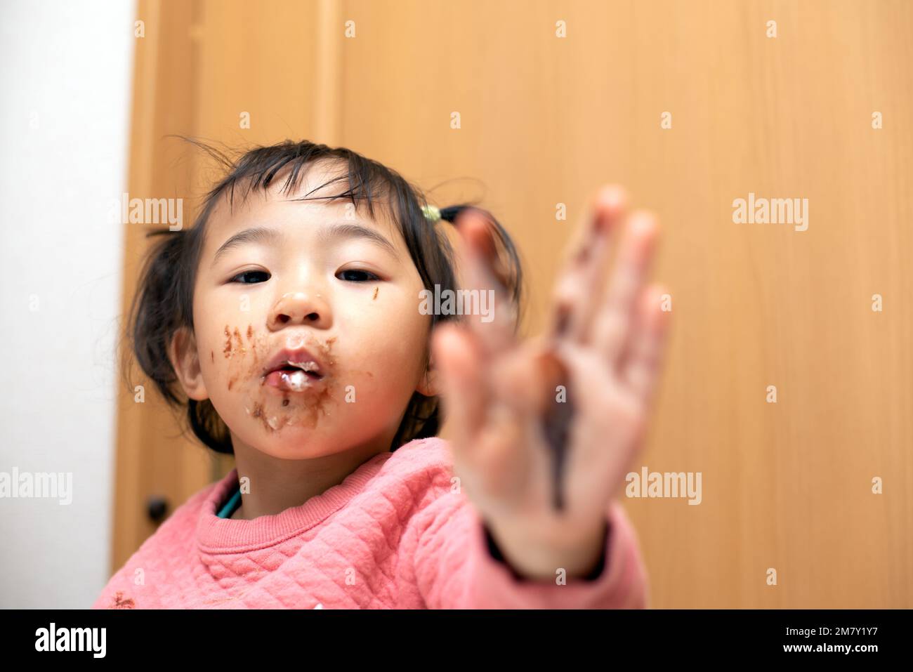 Un bambino o un bambino mangiava cioccolato con un viso disordinato Foto Stock