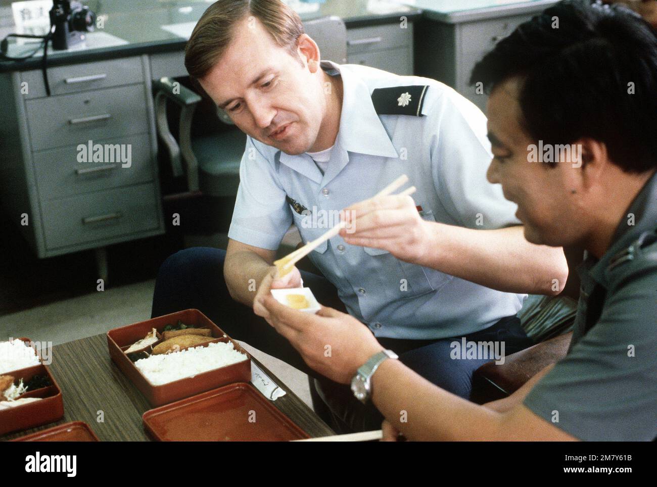 LTC Joseph Meeko, un ufficiale di scambio assegnato alla Japan Air Self Defense Force, mangia un pranzo in stile giapponese con LTC Hiroshi Nagashima, un istruttore di controllo e avvertimento aereo presso il college dello staff aereo. Base: Tokyo Paese: Giappone (JPN) Foto Stock