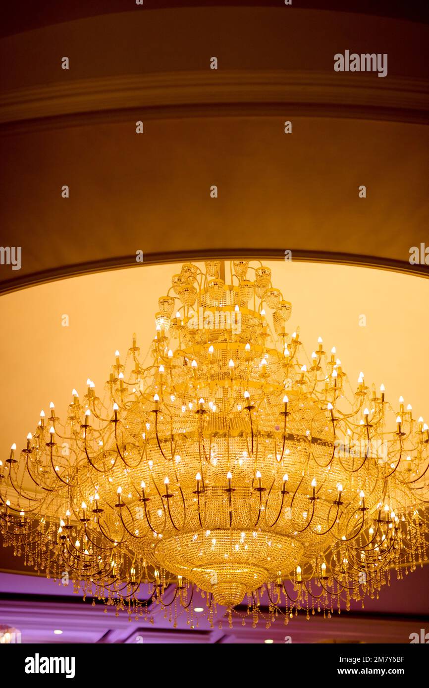 Un'inquadratura a basso angolo di un lussuoso lampadario appeso al soffitto,  con molte lampadine accese, decorate con ornamenti in vetro appesi Foto  stock - Alamy
