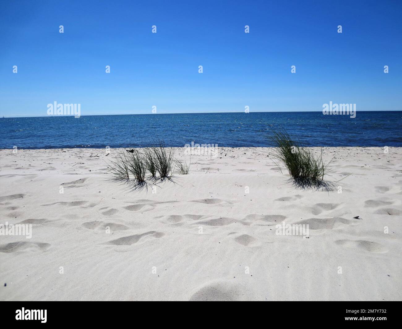 bellissima spiaggia di sabbia di fronte al mare blu Foto Stock