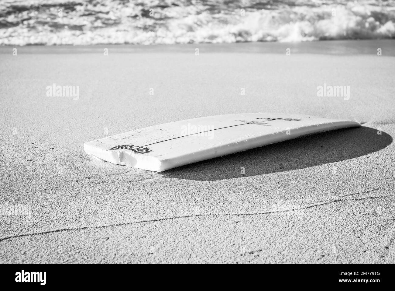 Una tavola da surf rotta in spiaggia Foto Stock