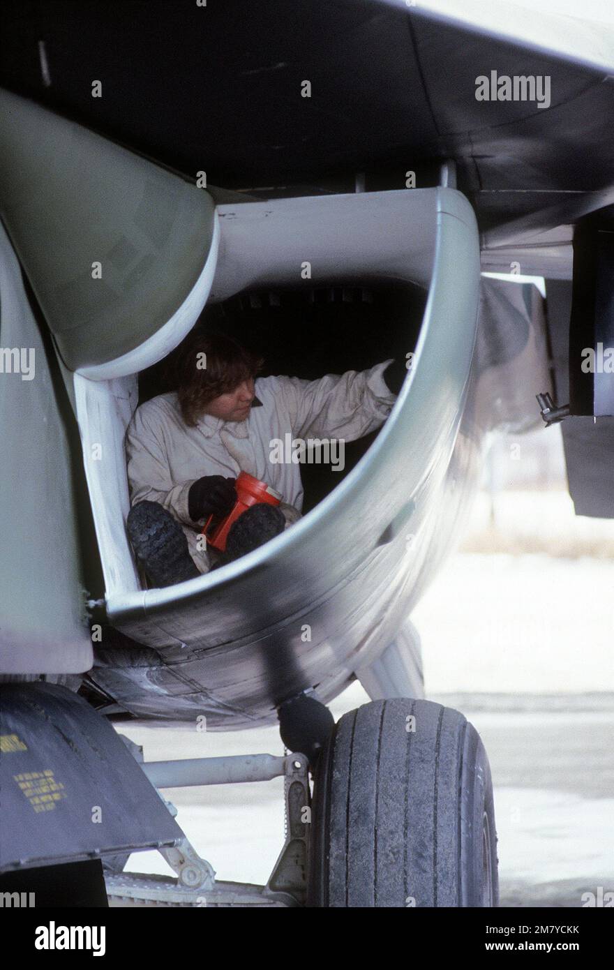 Un capo dell'equipaggio di terra ispeziona l'assunzione di un aeromobile F-111a. L'aviatore proviene dalla Tactical Fighter Wing 366th e sta partecipando all'esercitazione Brim Frost '81. Soggetto operativo/Serie: BRIM FROST '81 base: Elmendorf Air Force base Stato: Alaska (AK) Paese: Stati Uniti d'America (USA) Foto Stock