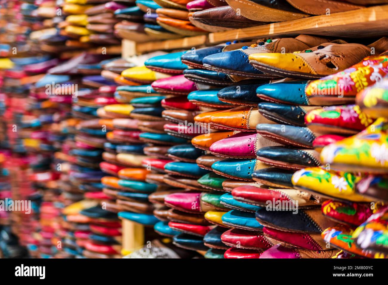 Pantofole colorate in pelle fatte a mano in attesa di clienti al negozio a Fes, vicino alle concerie, Marocco, Nord Africa Foto Stock