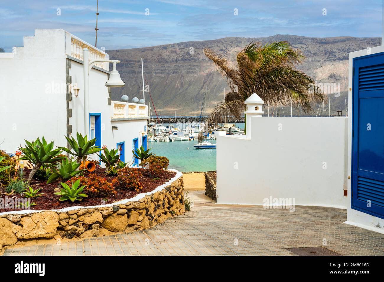 Paesaggio con architettura bianca, barche sull'oceano e vulcanica Lanzarote prese da Caleta del Sebo, la Graciosa , Isole Canarie, Spagna Foto Stock